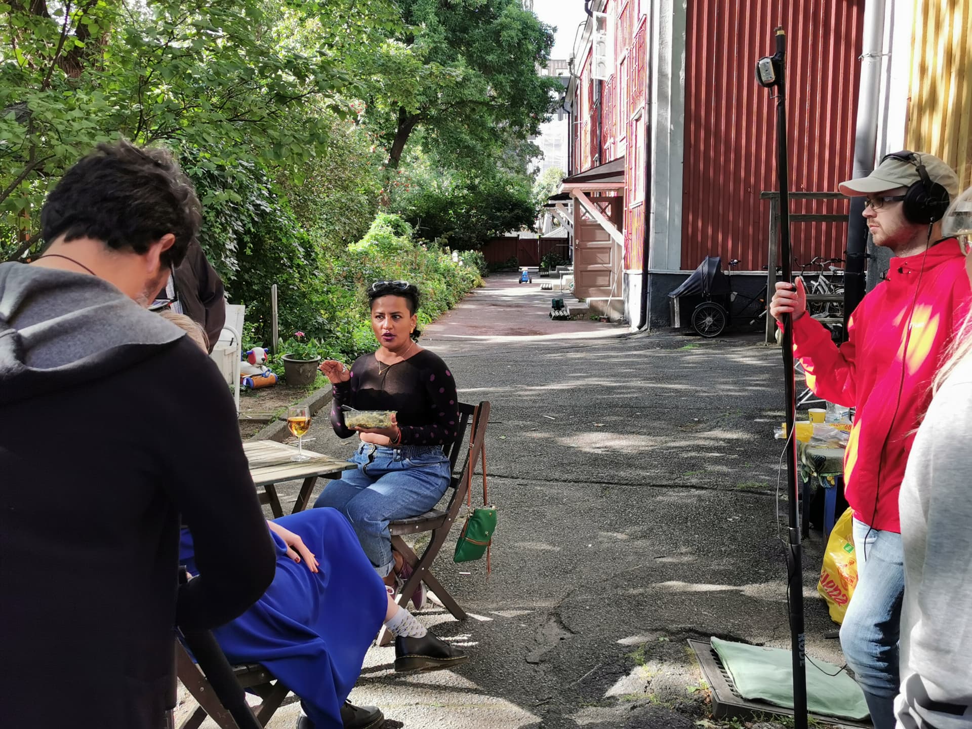Vishnu Vardhani Rajan seated in the courtyard between takes, crew gathered around